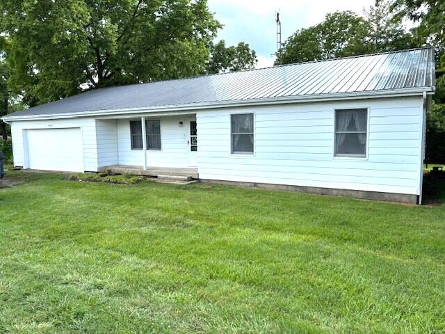 9050 N State Route 49, Greenville, OH 45331 - view of front of home featuring an attached garage, a front lawn, and a metal roof