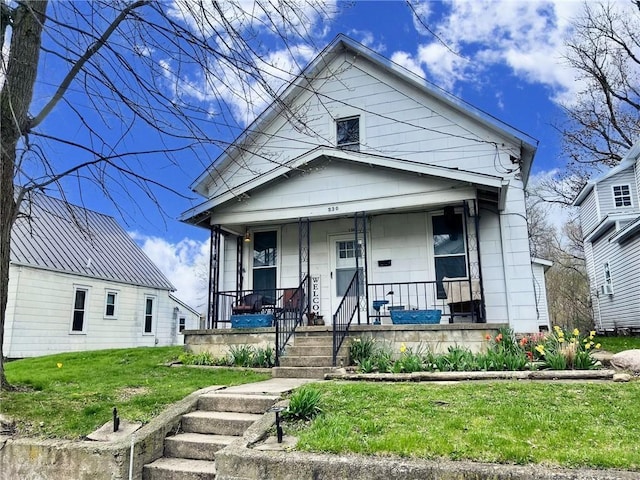 bungalow with a porch and a front lawn