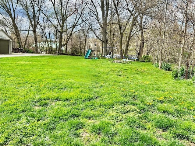 view of yard featuring a garage and a playground