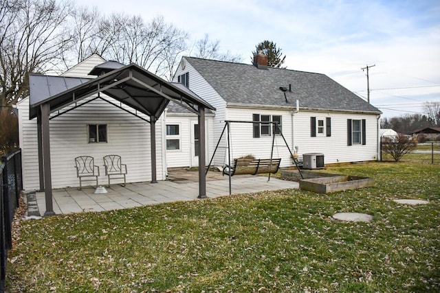 rear view of property featuring a lawn, a gazebo, a patio area, central AC, and fence