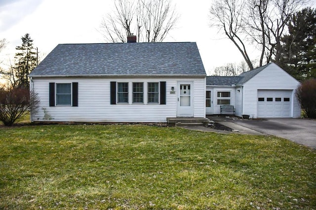 view of front facade featuring aphalt driveway, a chimney, a shingled roof, an attached garage, and a front yard