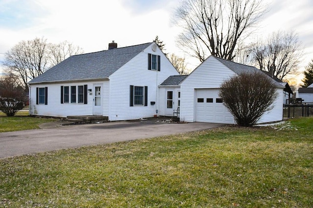 view of front of home featuring roof with shingles, a chimney, a front yard, a garage, and driveway