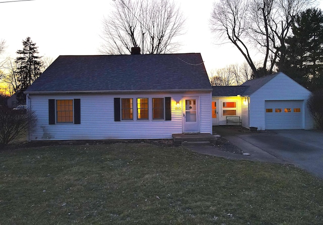 view of front facade featuring a garage, aphalt driveway, a front yard, and a shingled roof