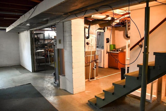 unfinished basement featuring washer / dryer and stairs