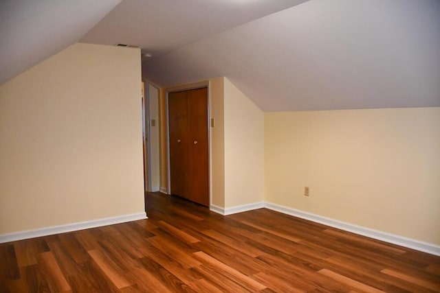 additional living space featuring lofted ceiling, baseboards, and wood finished floors