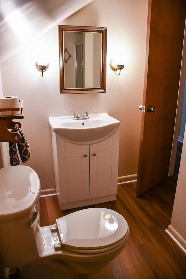 bathroom with baseboards, vanity, toilet, and wood finished floors