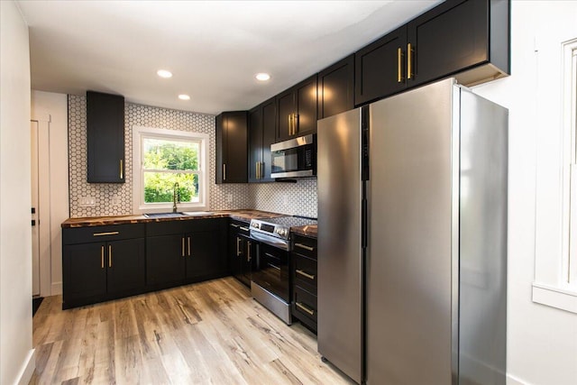 188 S Walnut St, Germantown, OH 45327 - kitchen with appliances with stainless steel finishes, light wood finished floors, decorative backsplash, recessed lighting, and dark cabinets
