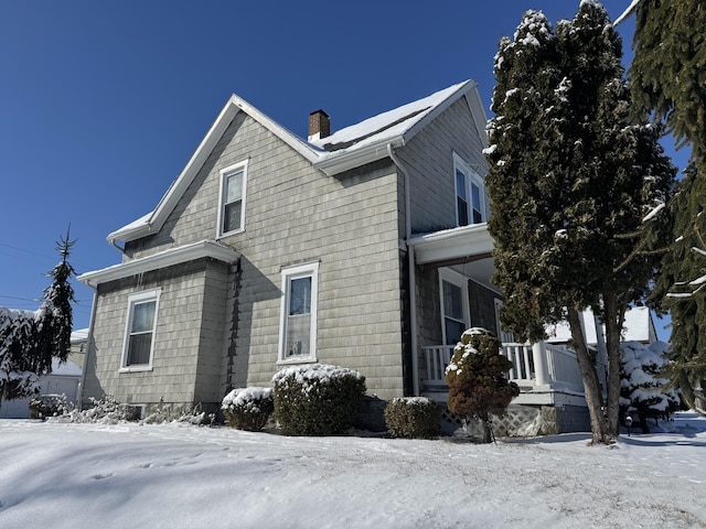 view of snowy exterior with covered porch