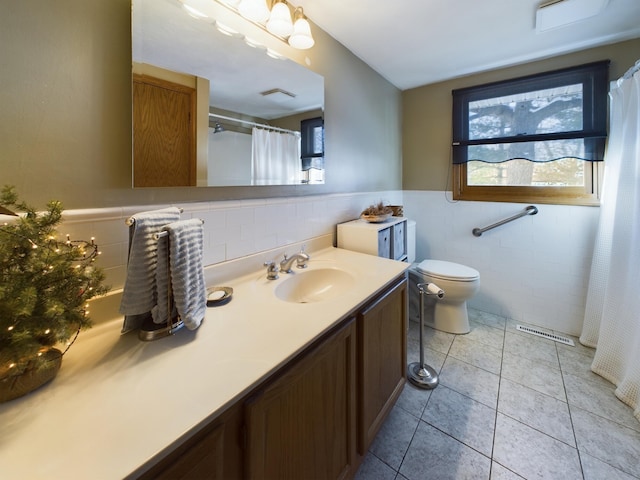 bathroom featuring tile walls, toilet, vanity, and tile patterned flooring