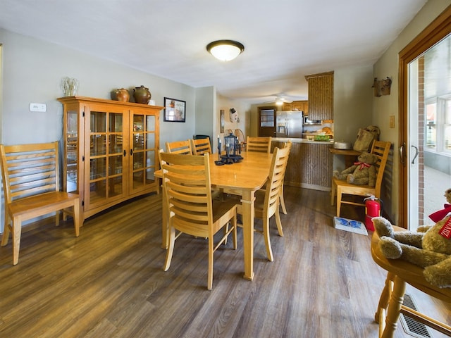 dining area with ceiling fan and dark hardwood / wood-style flooring