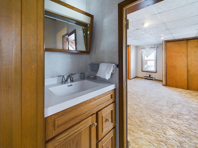 bathroom featuring vanity, a paneled ceiling, and a baseboard heating unit