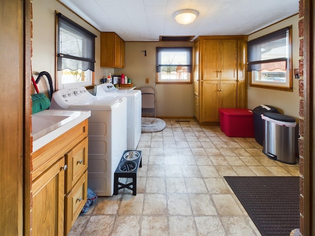 clothes washing area featuring washing machine and clothes dryer and cabinets