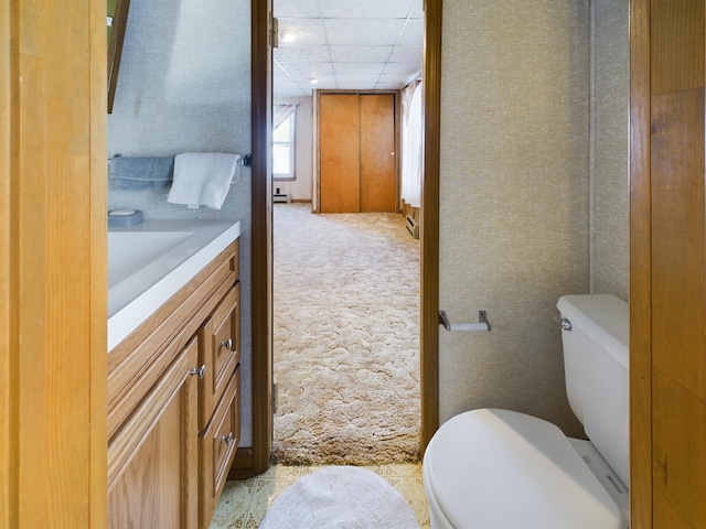 bathroom featuring a paneled ceiling, toilet, and vanity