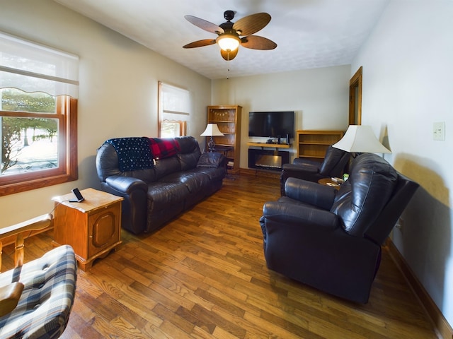 living room featuring dark wood-type flooring and ceiling fan