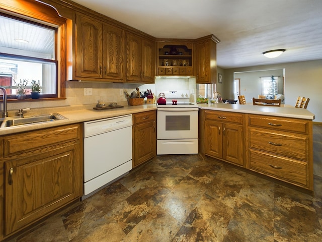 kitchen with sink, white appliances, and kitchen peninsula