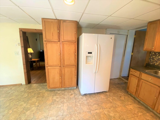 116 N Mill St, De Graff, OH 43318 - kitchen featuring white fridge with ice dispenser, a drop ceiling, dark countertops, brown cabinets, and a sink