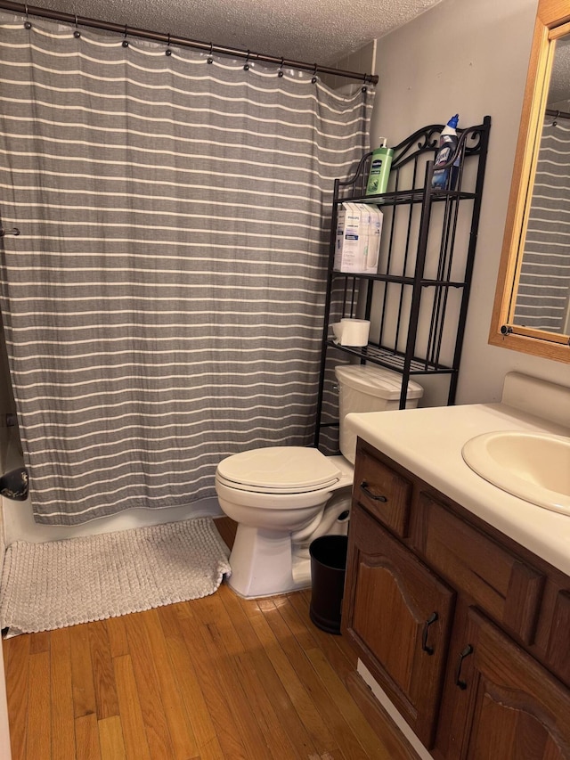1008 Manor Ln Unit C, Columbus, OH 43221 - bathroom with a textured ceiling, wood finished floors, toilet, vanity, and shower / tub combo