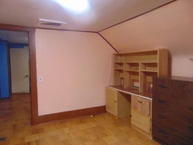 unfurnished office with vaulted ceiling and built in desk