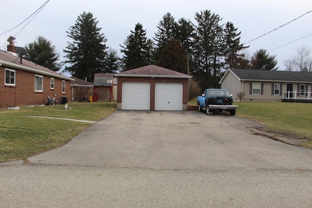 exterior space featuring brick siding, central AC unit, a garage, an outdoor structure, and a front lawn