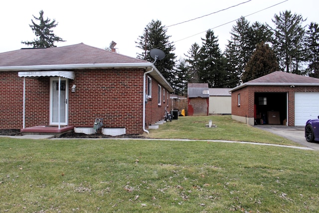 view of home's exterior featuring brick siding, a lawn, and an outbuilding