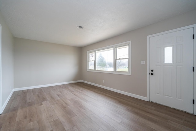 foyer entrance featuring light hardwood / wood-style flooring and a textured ceiling