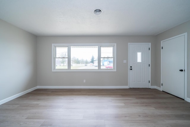 foyer entrance featuring a textured ceiling and light hardwood / wood-style flooring