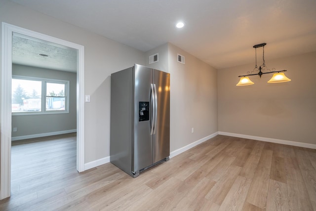 kitchen featuring stainless steel refrigerator with ice dispenser, light hardwood / wood-style flooring, and pendant lighting