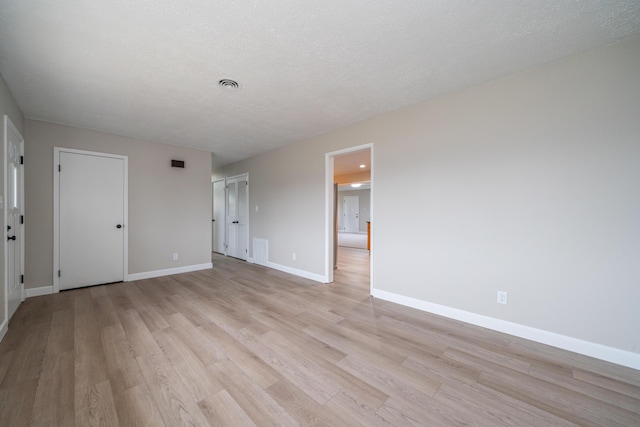 spare room with light hardwood / wood-style flooring and a textured ceiling