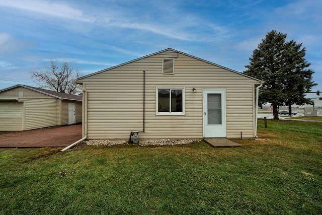 rear view of house with an outdoor structure and a lawn