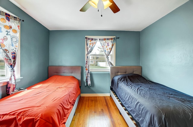 bedroom featuring hardwood / wood-style flooring, baseboards, and a ceiling fan