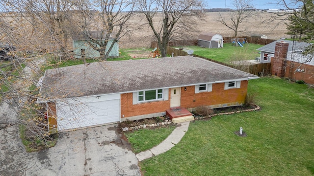 ranch-style house with concrete driveway, fence, an attached garage, brick siding, and a front lawn
