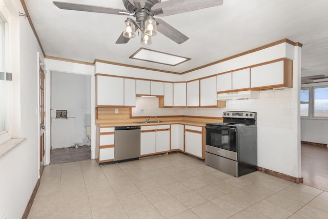 kitchen featuring light countertops, under cabinet range hood, a sink, a ceiling fan, and appliances with stainless steel finishes