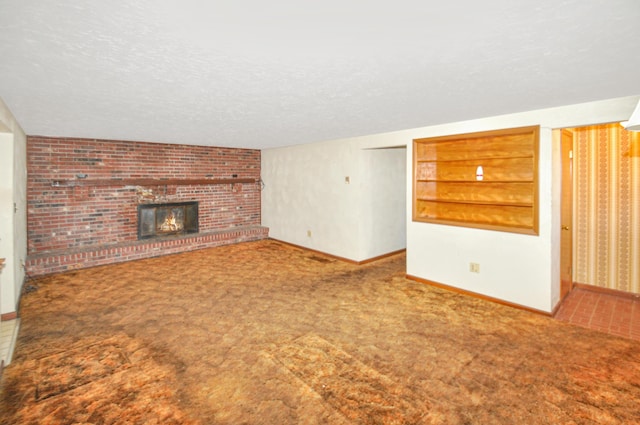 unfurnished living room with baseboards, a brick fireplace, a textured ceiling, and carpet