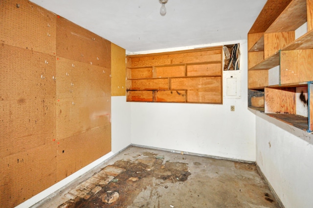 spare room with electric panel and unfinished concrete floors