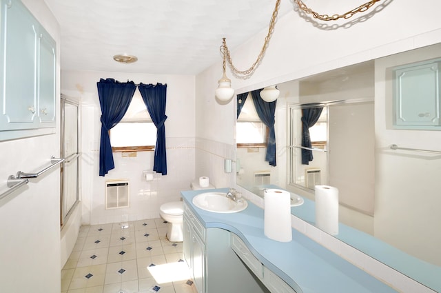 full bath featuring tile walls, toilet, wainscoting, heating unit, and vanity