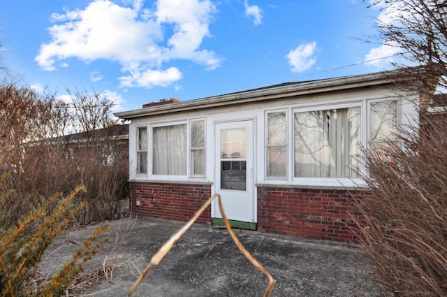 view of exterior entry featuring brick siding