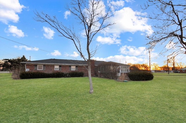 ranch-style house with brick siding and a front yard