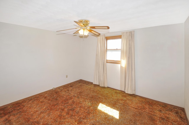 carpeted spare room featuring a ceiling fan