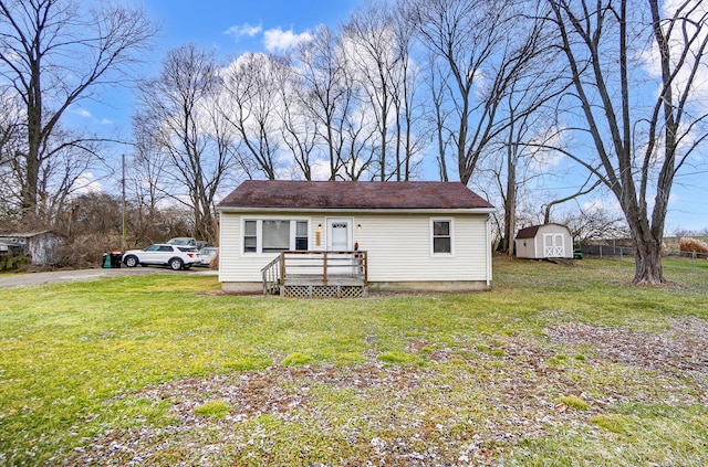 view of front of property with a storage shed and a front yard