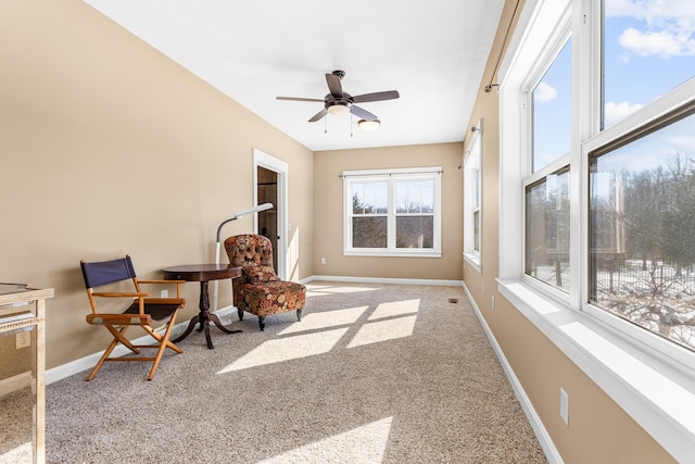 living area featuring ceiling fan, carpet flooring, and baseboards