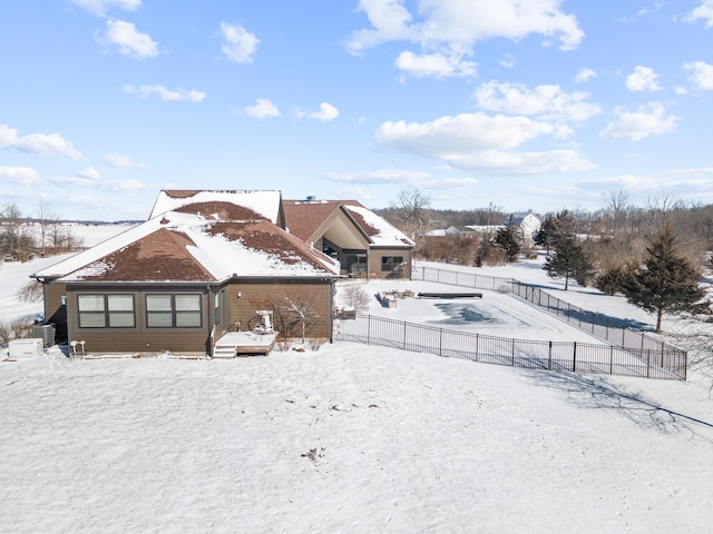 snow covered property featuring fence and central AC unit