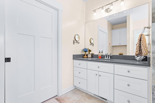 bathroom with visible vents, baseboards, vanity, and tile patterned floors