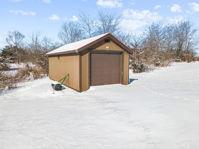 snow covered structure with an outbuilding