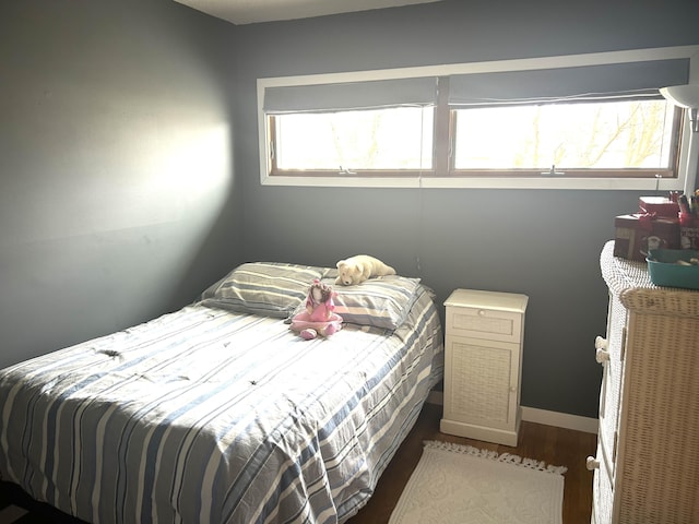bedroom with baseboards and wood finished floors