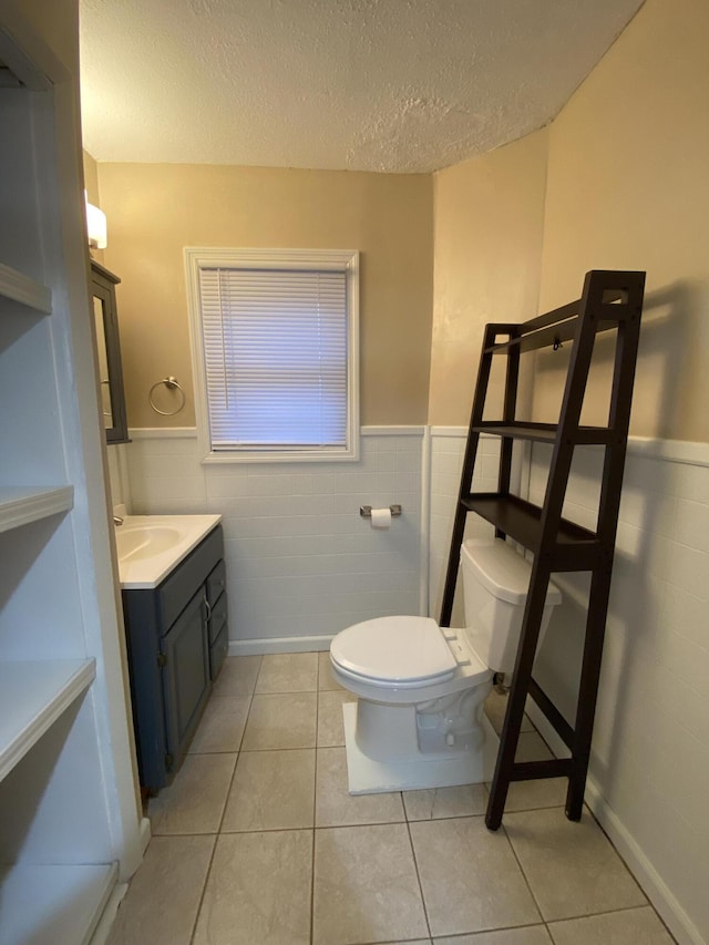 465 Miami St, Piqua, OH 45356 - half bath with wainscoting, a textured ceiling, vanity, tile patterned flooring, and tile walls