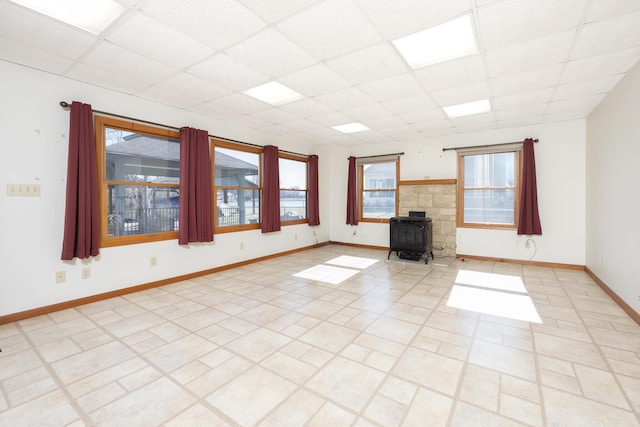 7868 Beech Ave, Russells Point, OH 43348 - unfurnished living room with a drop ceiling, a wood stove, and baseboards