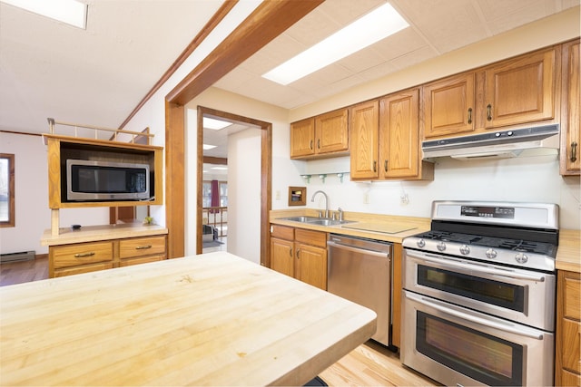 7868 Beech Ave, Russells Point, OH 43348 - kitchen with stainless steel appliances, a sink, under cabinet range hood, baseboard heating, and light wood finished floors