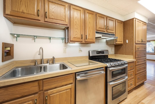 7868 Beech Ave, Russells Point, OH 43348 - kitchen with stainless steel appliances, under cabinet range hood, a sink, light countertops, and light wood finished floors