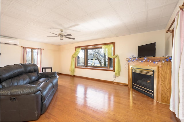 7868 Beech Ave, Russells Point, OH 43348 - living room with a wall mounted air conditioner, wood finished floors, a glass covered fireplace, and baseboards