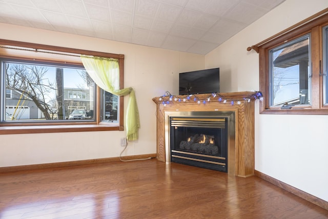 7868 Beech Ave, Russells Point, OH 43348 - living area featuring wood finished floors, a glass covered fireplace, and baseboards